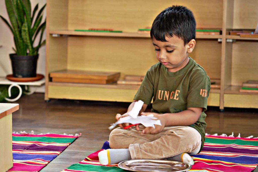 Toddler engaged in a practical life activity at Eduland Montessori in Banashankari, Bangalore, developing independence and fine motor skills through hands-on learning.