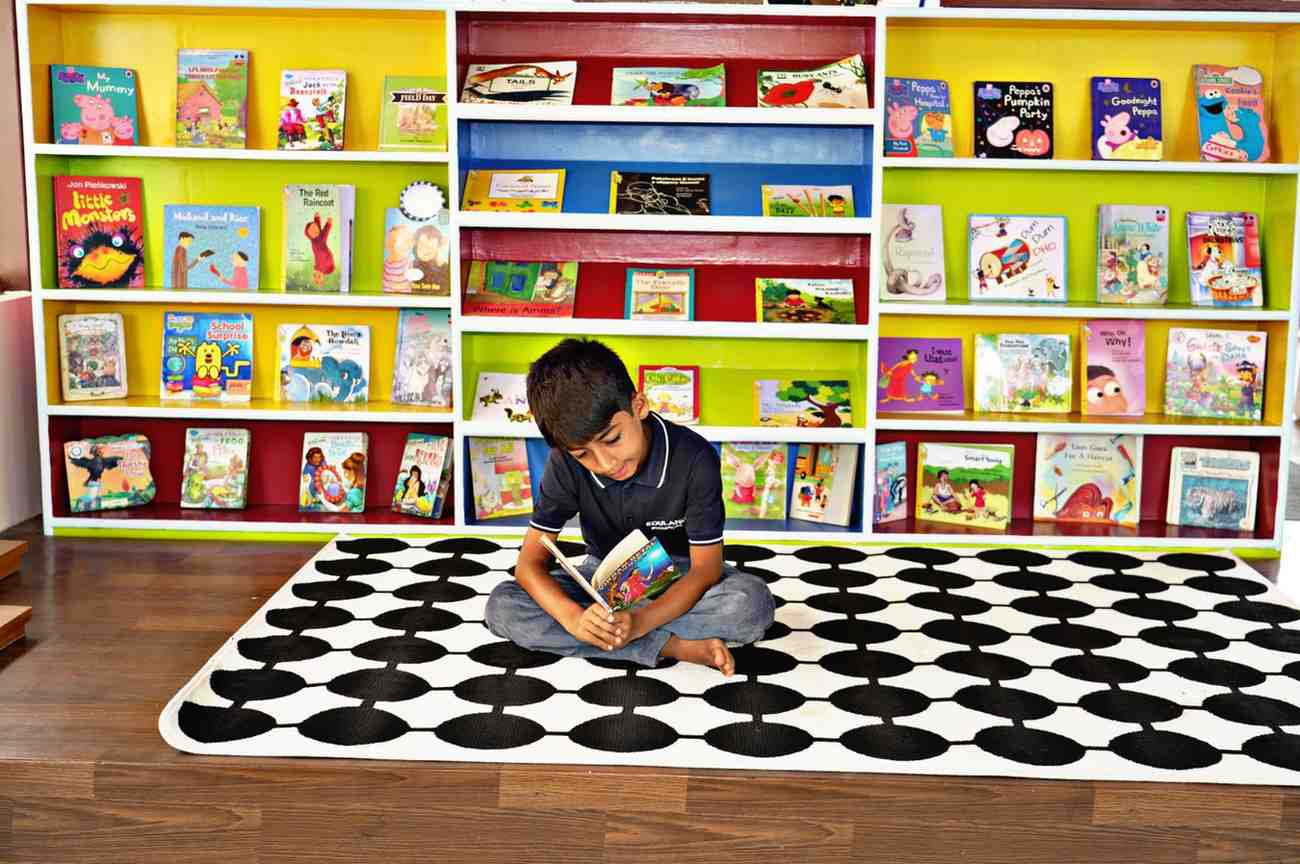 Child reading independently in a Montessori classroom at Eduland Montessori, Banashankari, Bangalore, developing concentration, language, and a love for reading